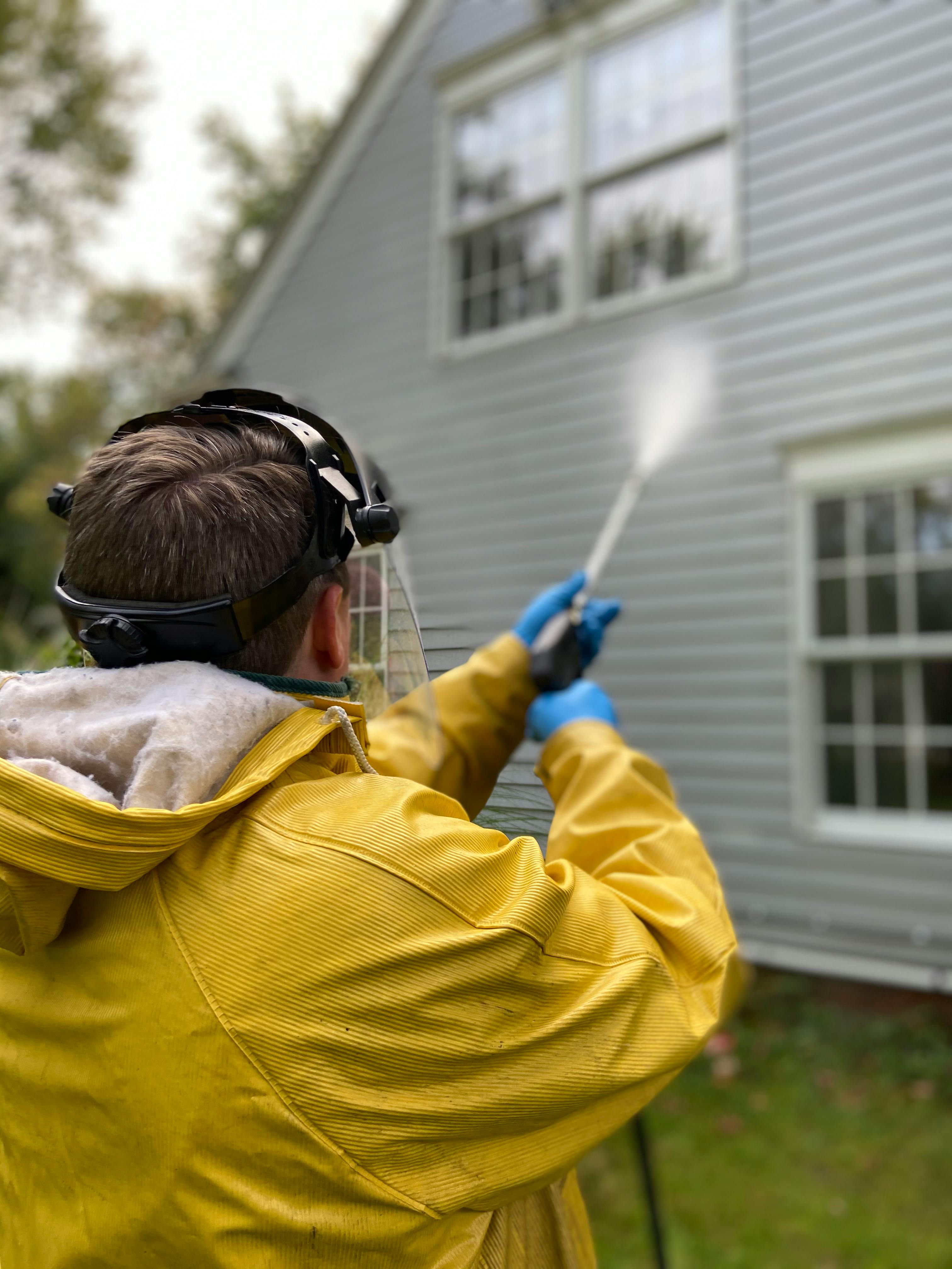 Technician power washing the siding of a residential home