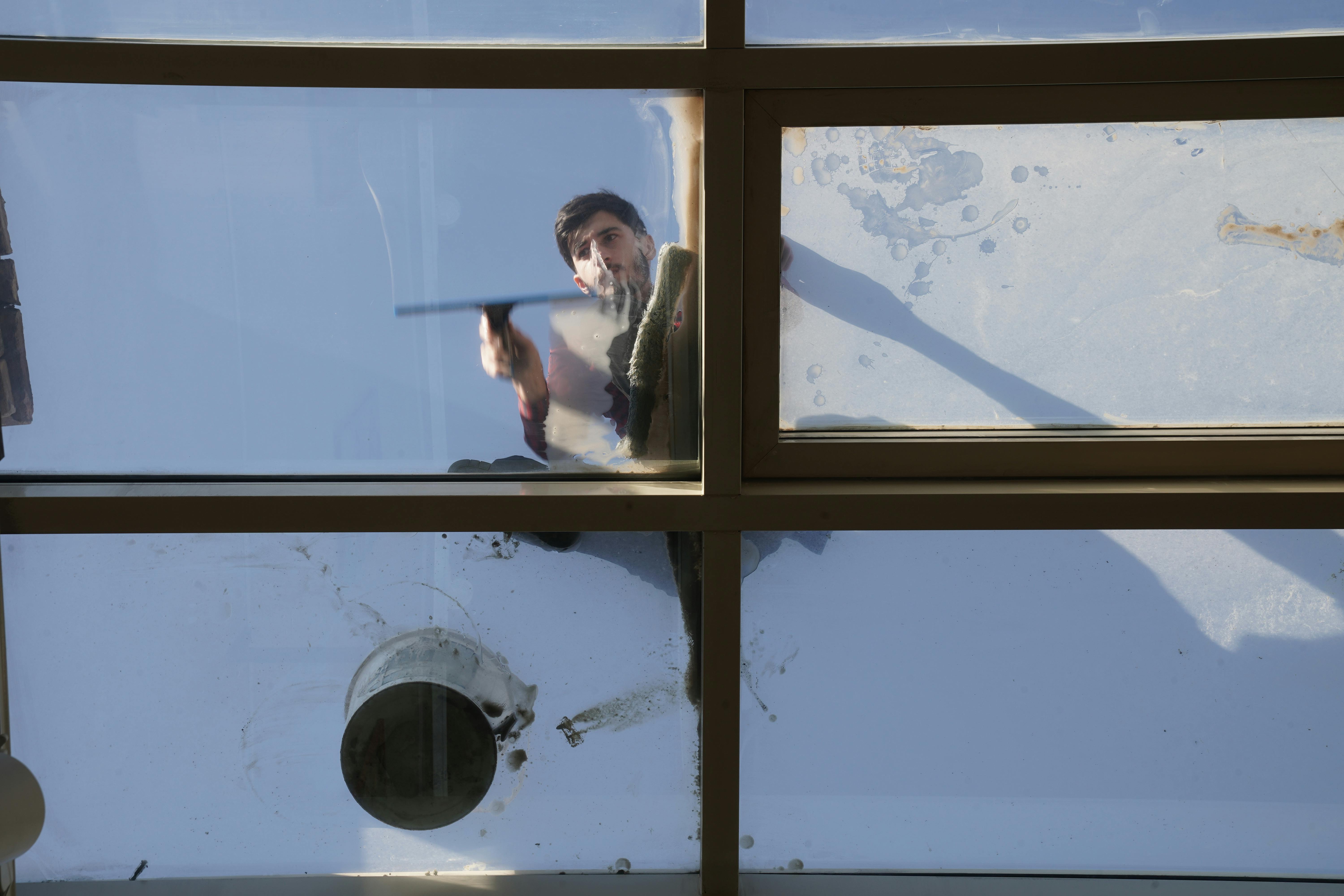 Worker cleaning large exterior windows